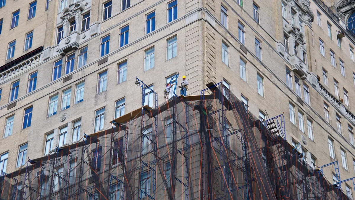 Scaffold workmen on high rise facade