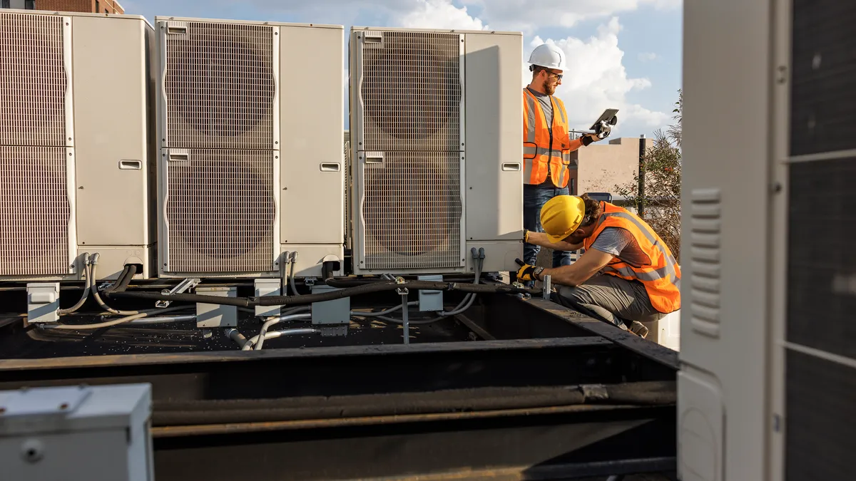 Team works together to inspect an air conditioner on a rooftop