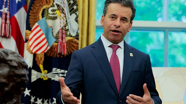 man in a dark blue suit speaks in the oval office