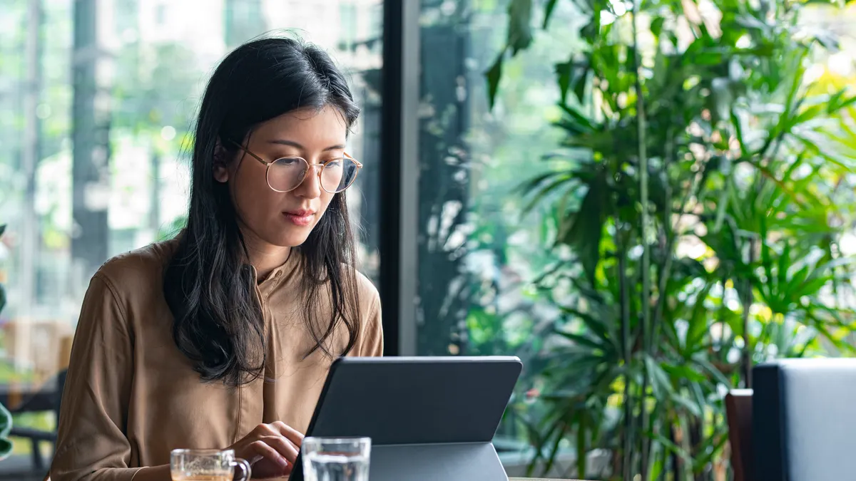 businesswoman sitting at a cafe and using a tablet