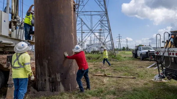 Service technicians work to install the foundation for a transmission tower.
