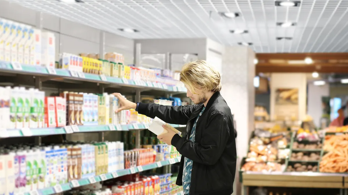 Man choosing frozen food from a supermarket freezer.