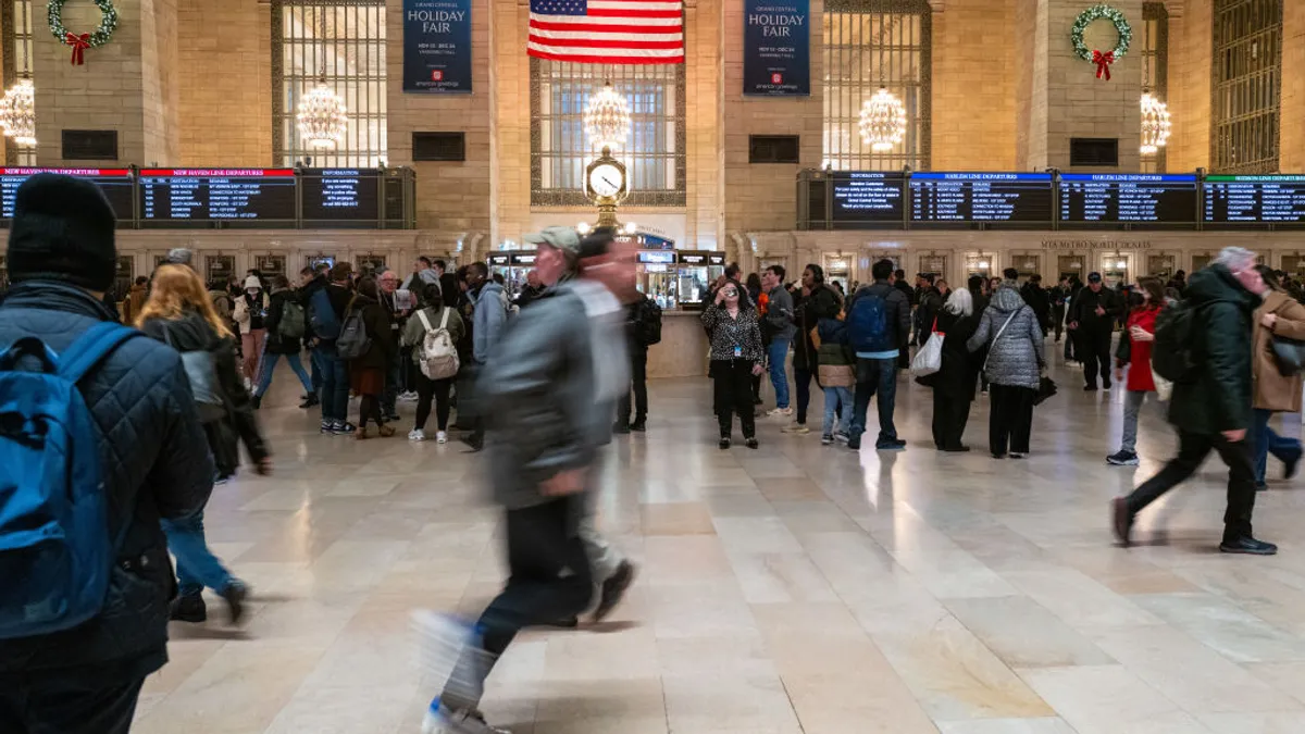 A traveler is blurry as he rushes through a station.