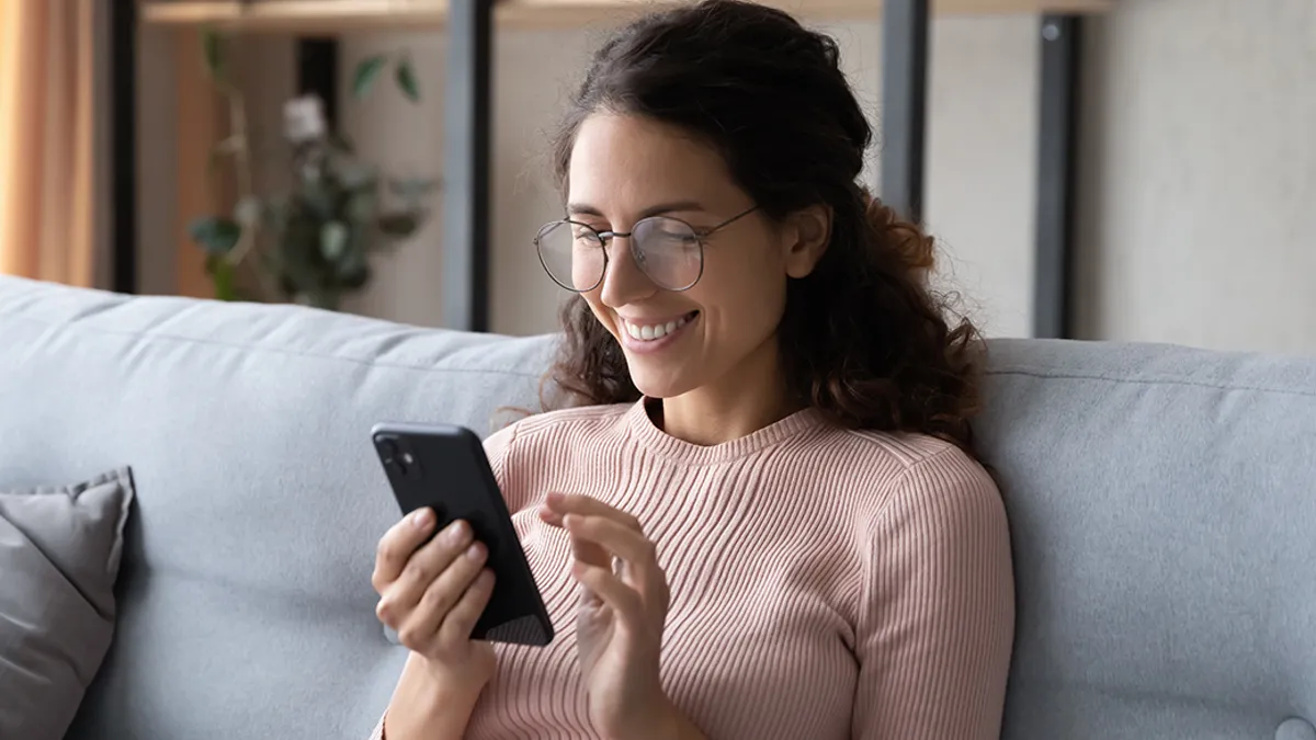 Woman relaxing on sofa, enjoying web surfing information in internet