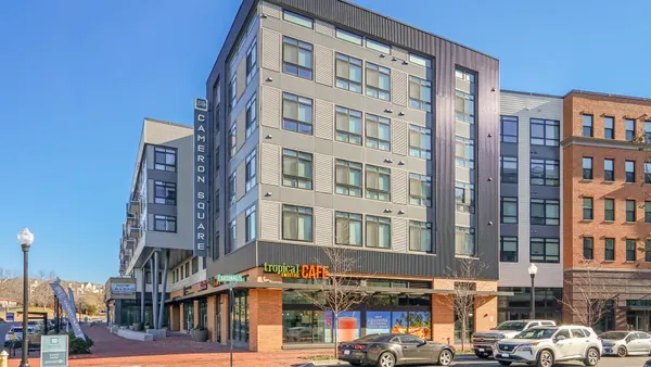 Mixed-use apartment community next to a sidewalk.