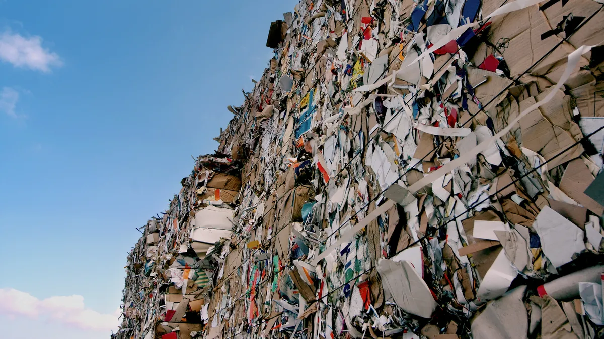 Baled paper in a stack, blue sky above