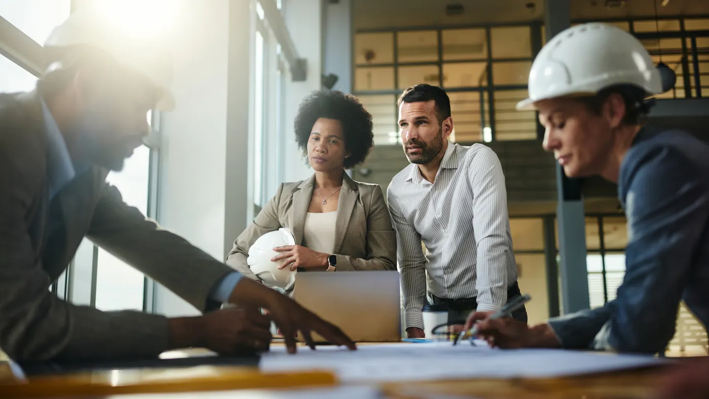 A diverse group of project stakeholders discuss construction plans.