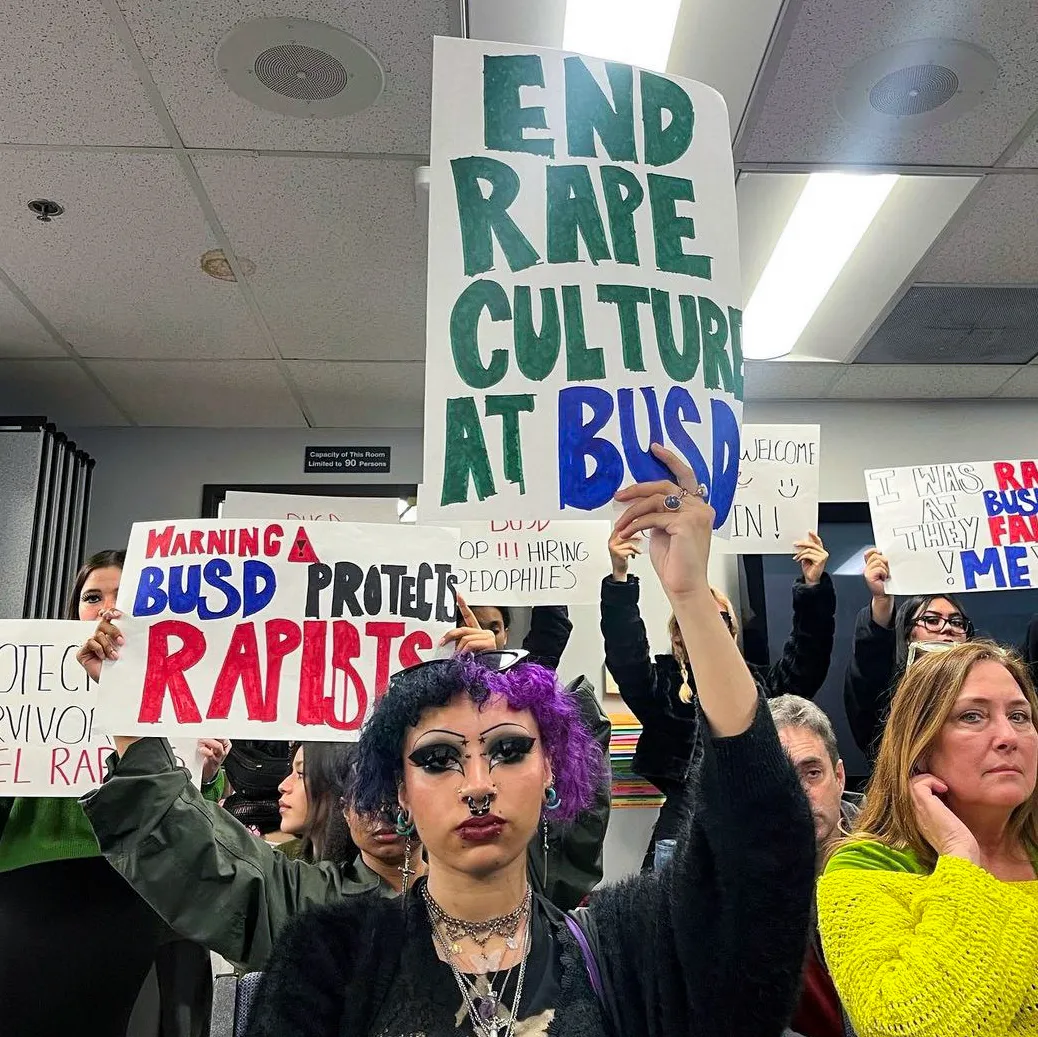 Students hold protest signs