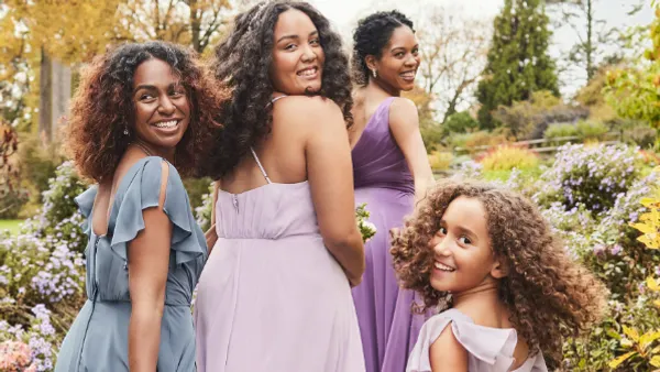 Group of four women wearing bridesmaid dresses.
