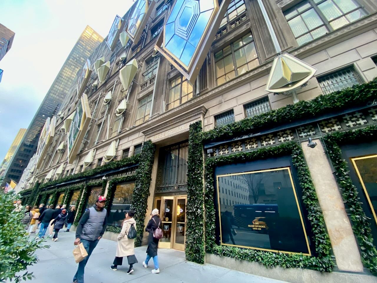 People walking past a city department store building.