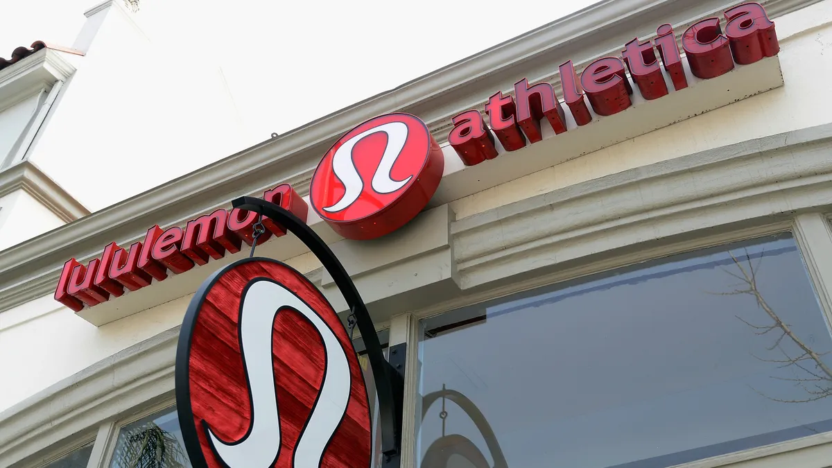 A close up of the Lululemon sign on a store front.