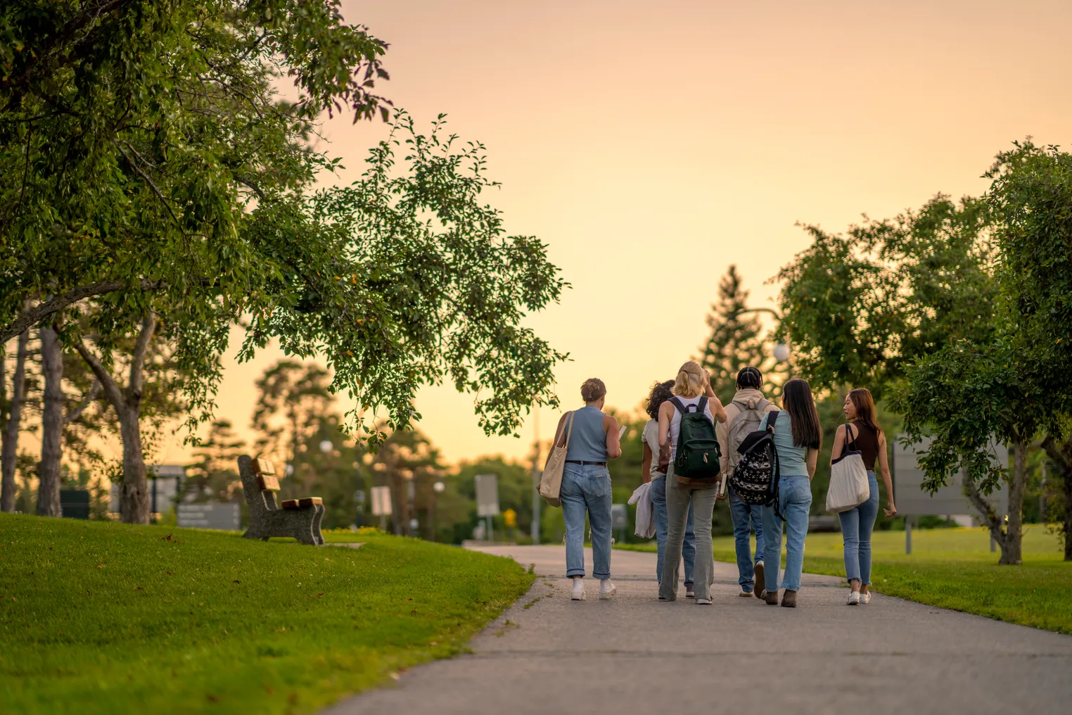 A group of college students walking on a campus pathway.