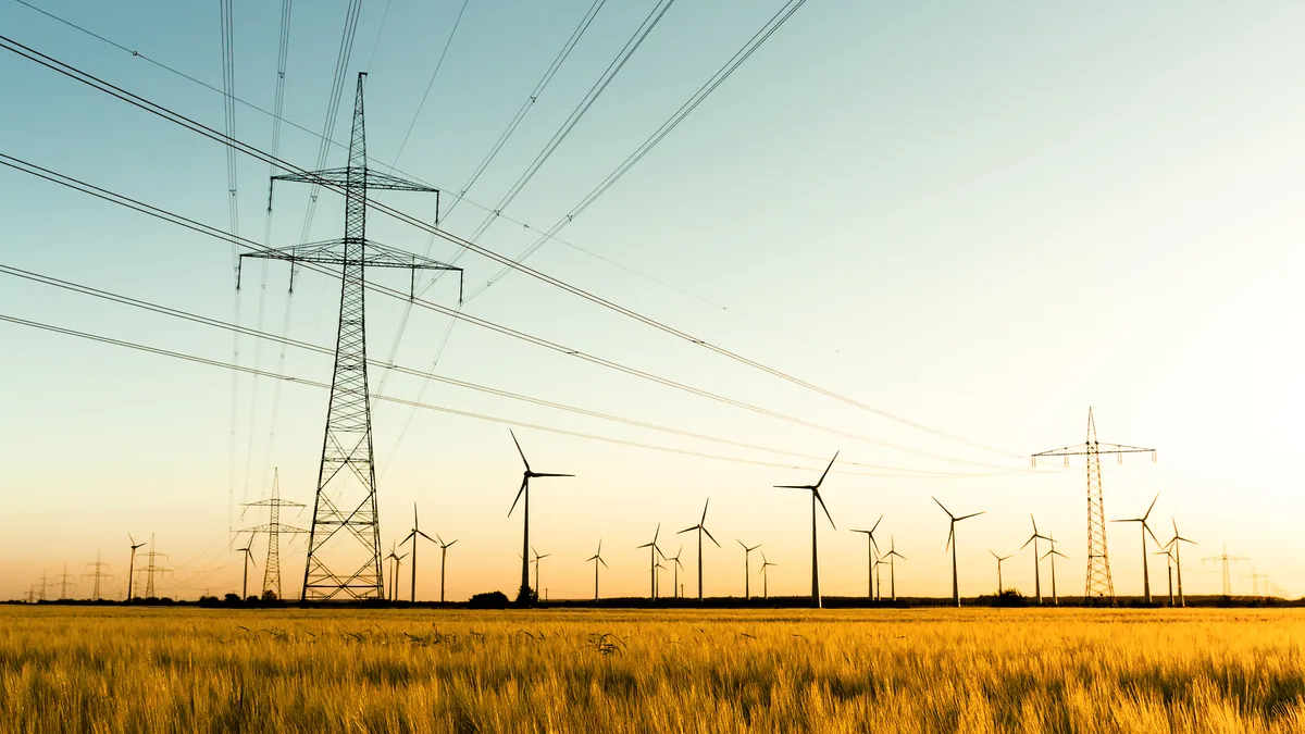 Corn field with transmission lines and wind turbines.