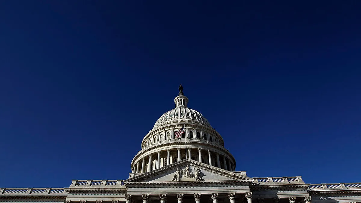 The U.S. capitol building stands in front of a blue sky.