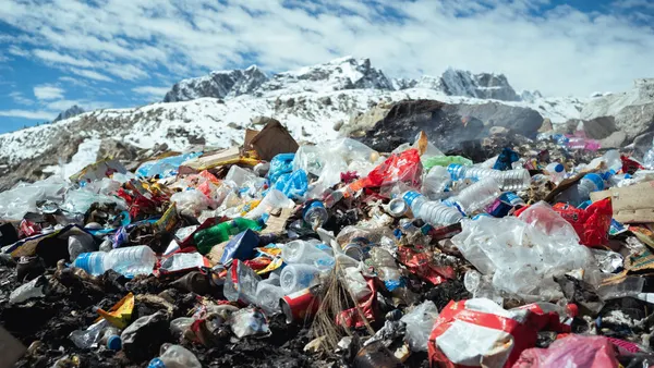 A pile of plastic waste seen in front of a mountain range.