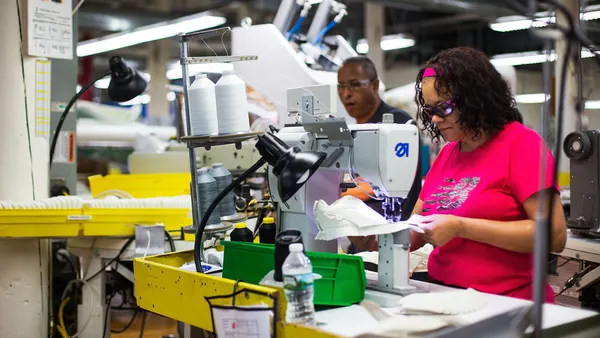 Workers manufacturer shoes in a factory.