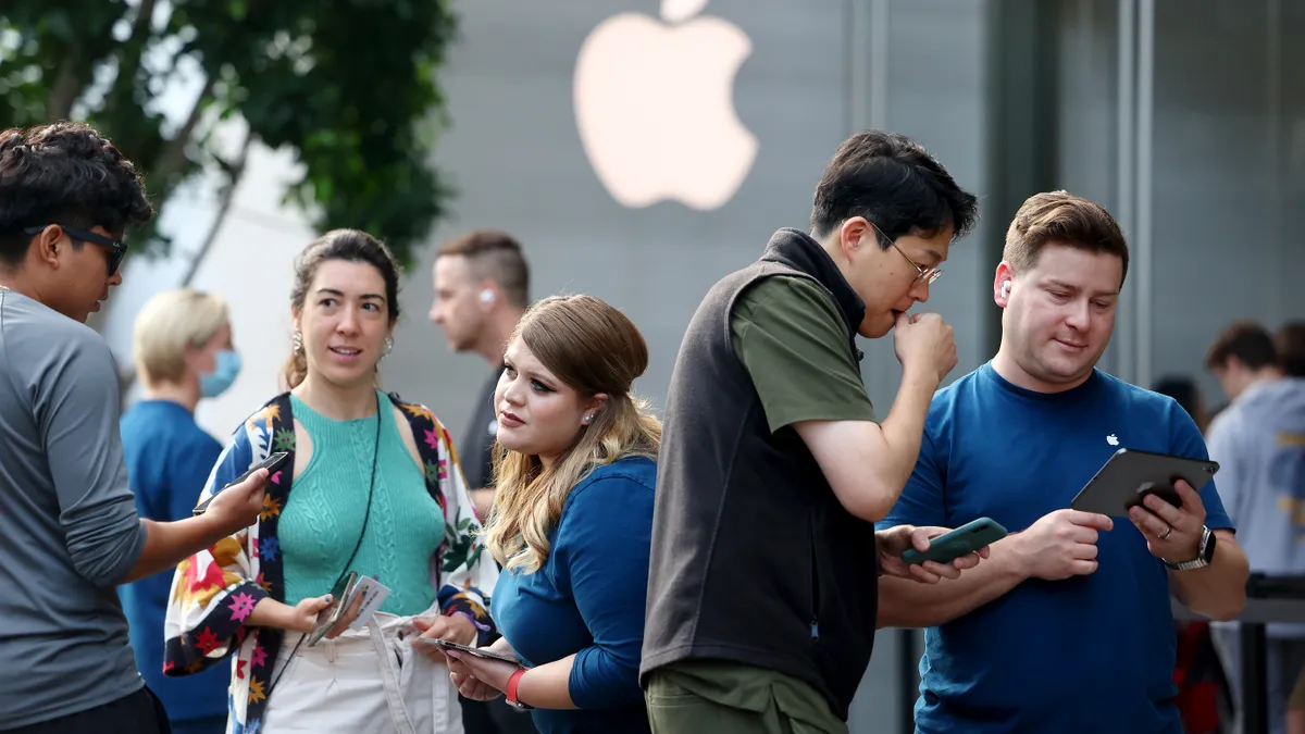 People wait in line to purchase new Apple iPhone 15 models.