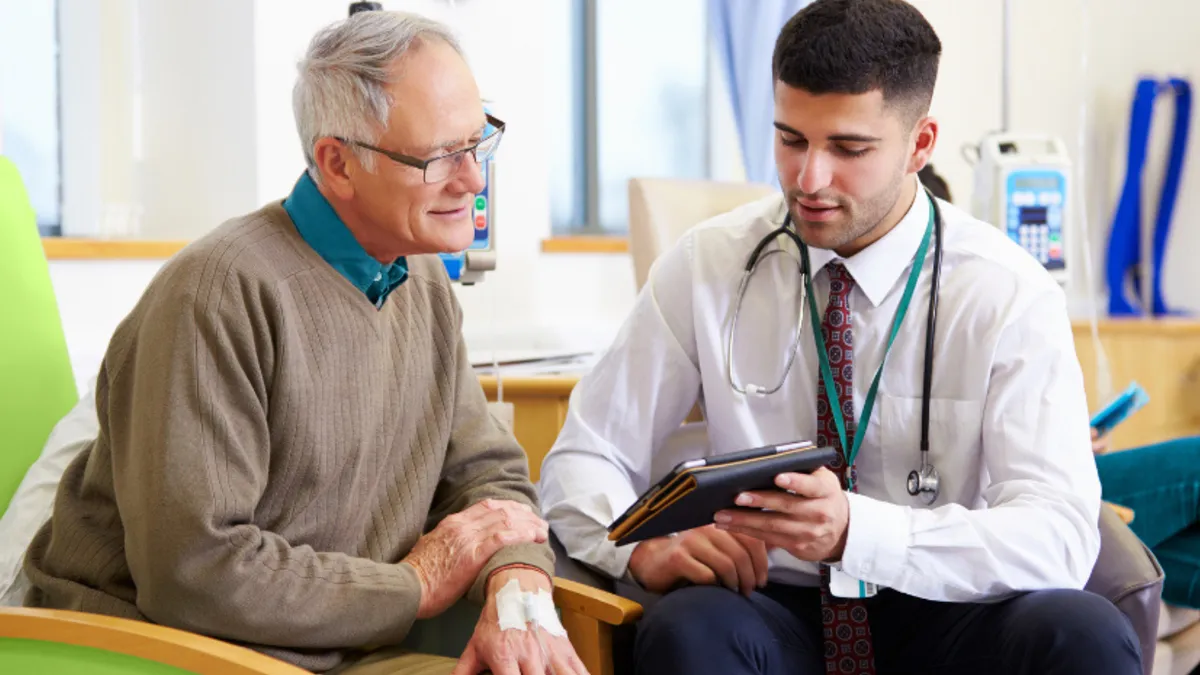 Young doctor talking to an old patient