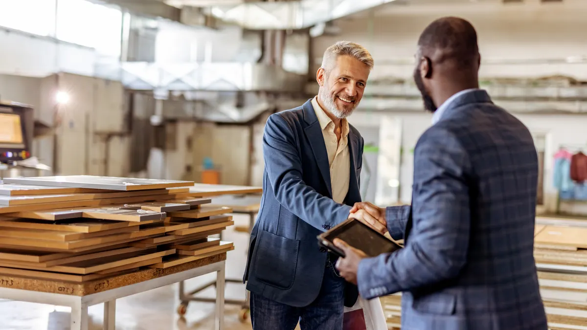Two individuals in business attire greeting each other