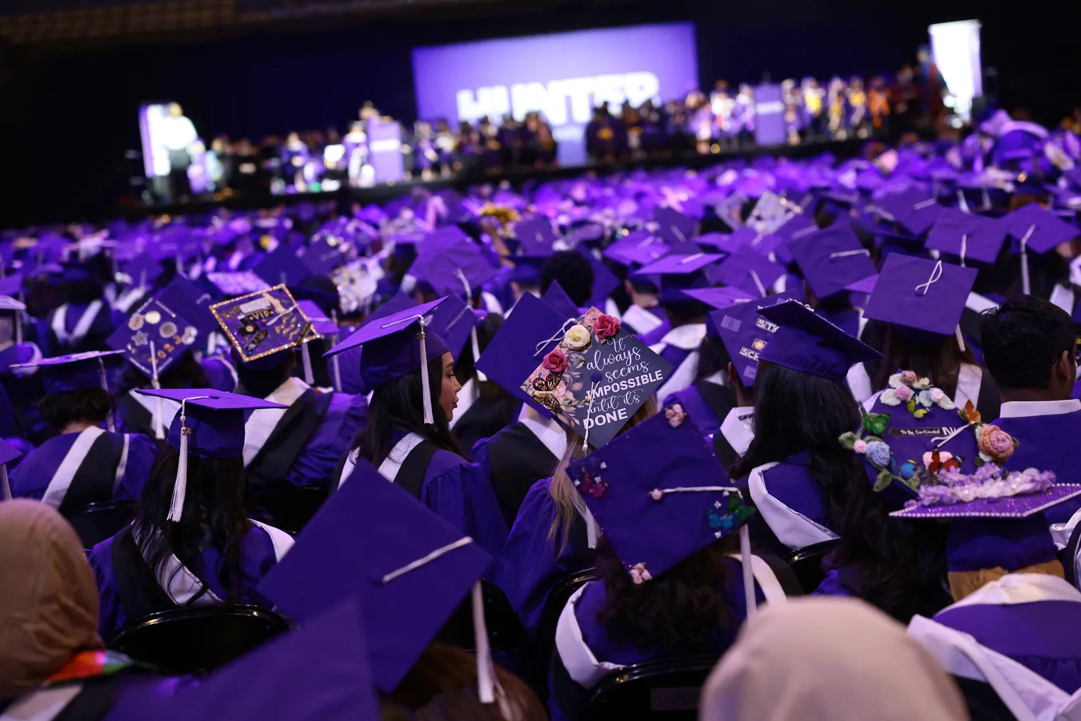 A sea of graduation caps is seen as students listen to a commencement address.