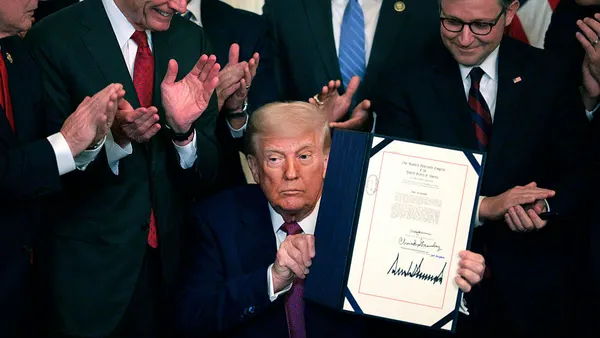 U.S. President Donald Trump holds up an executive order he signed at the White House.