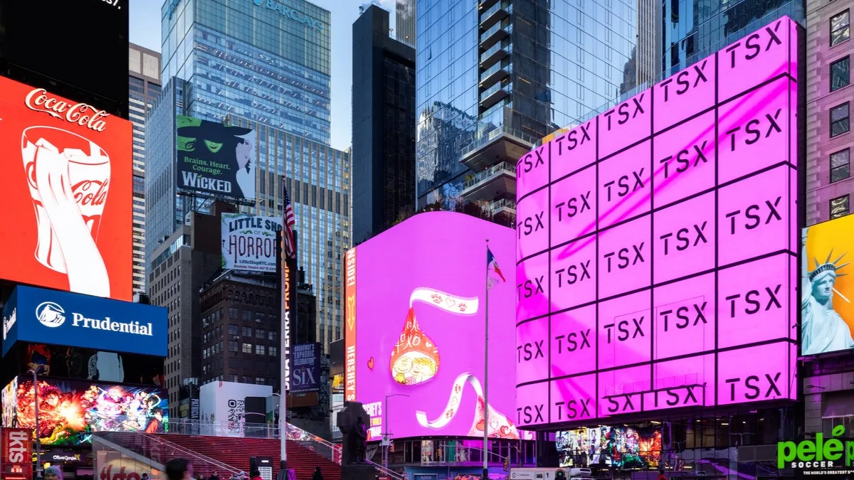 An exterior shot of the LED screen, made up of large, pink cubes that say "TSX."