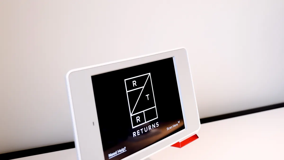 Tablet computer showing Rent the Runway return starting screen with Nordstorm sign on the wall behind it.