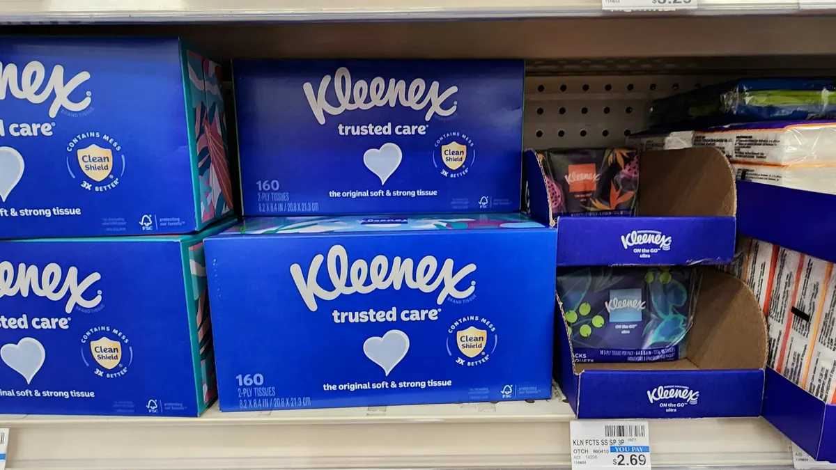 Blue boxes of Kleenex tissue on a store shelf.