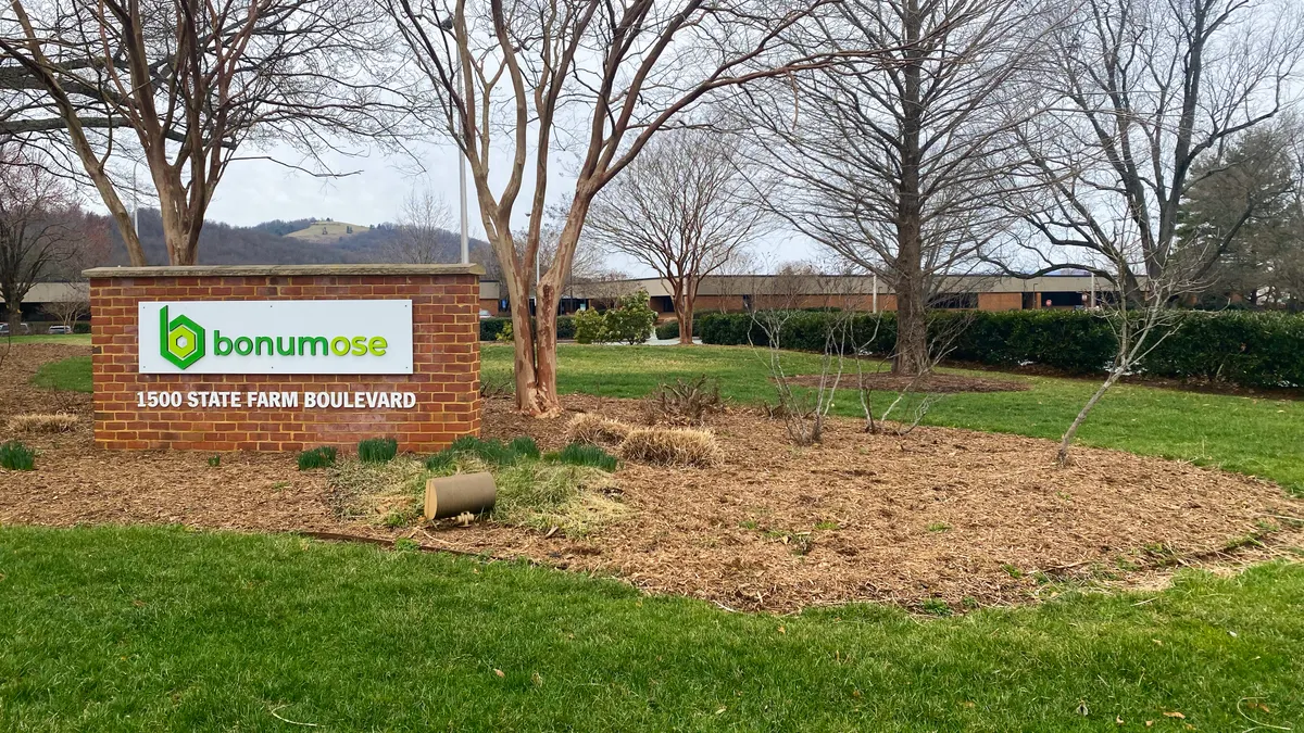 A Bonumose sign sits in front of a large brick headquarters building.