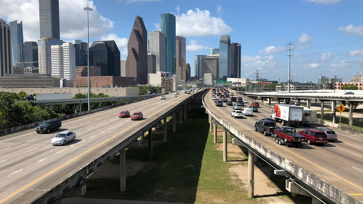 Three separate elevated highways lead to the Houston skyline in the background.