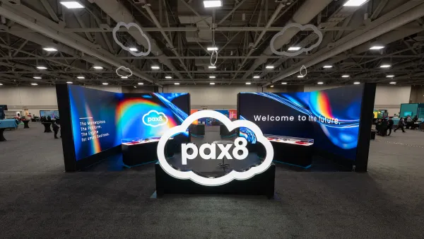 A installation for technology provider Pax8 stands in the center of a convention center lobby.
