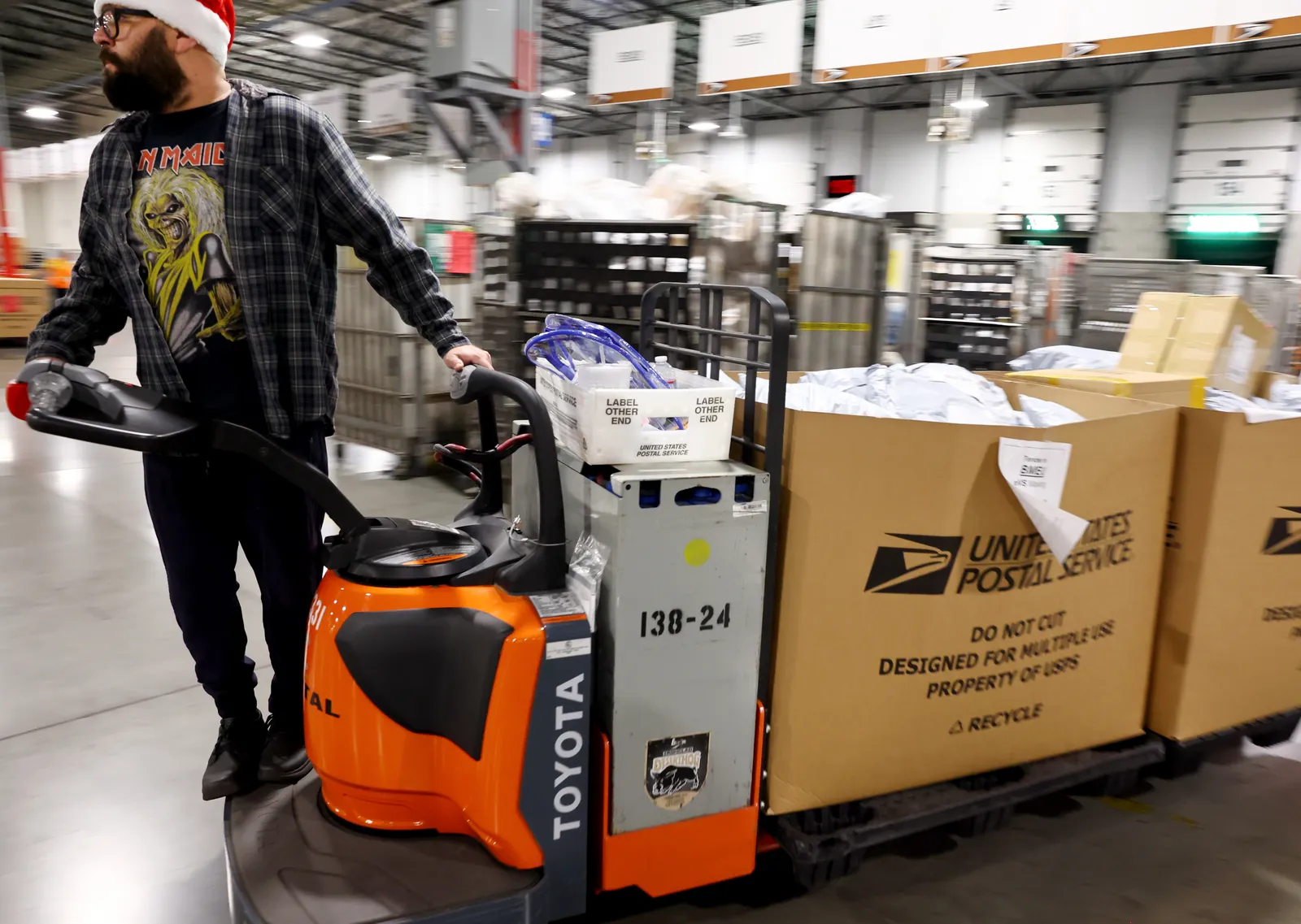 A U.S. Postal Service employee transports parcels for distribution ahead of the holiday mail rush inside the Los Angeles Processing and Distribution Center on November 30, 2022 in Los Angeles, Califor