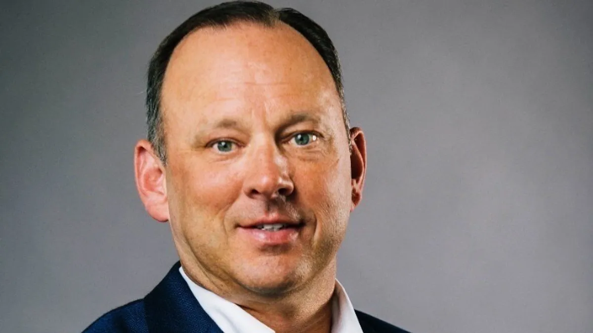 A man in a white shirt and suit jacket.