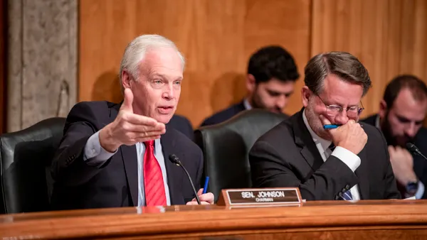 Senator Ron Johnson speaking behind a dais.