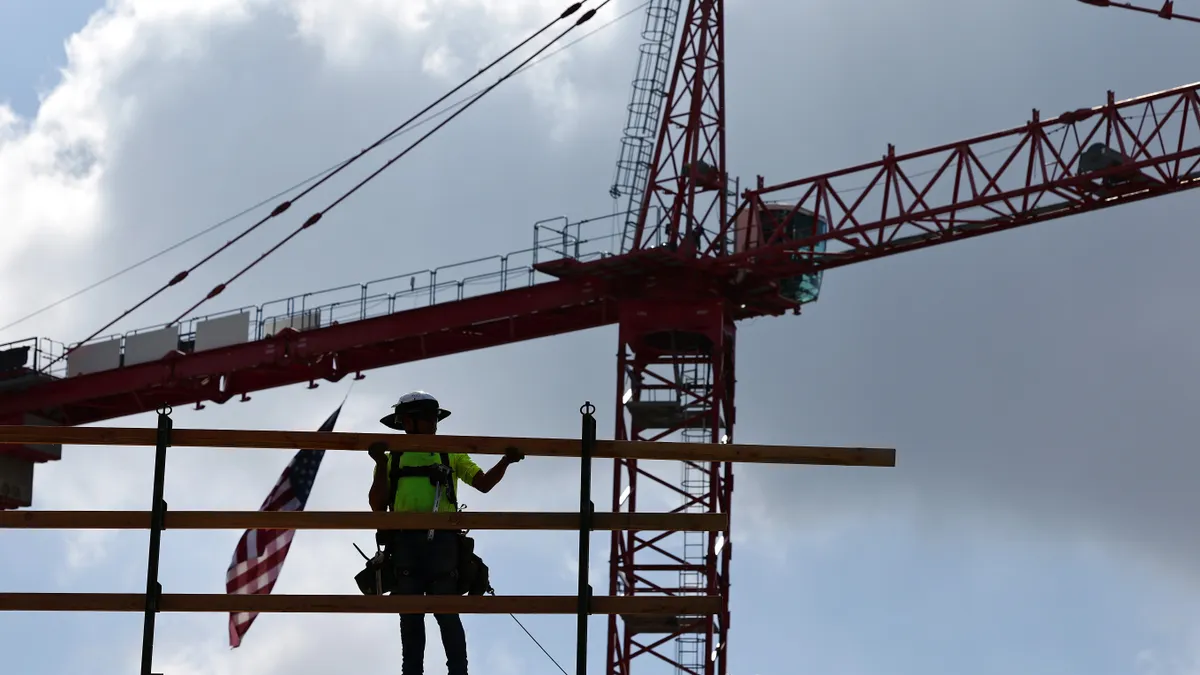 A construction worker helps build a mixed-use apartment complex which will hold over 700 units of apartment housing and 95,000 square feet of commercial space on January 25, 2024 in Los Angeles.