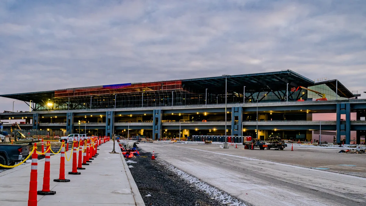 A shot of a large building in the background, with the construction on the structure in progress. The skeleton of the building is open to the public eye.