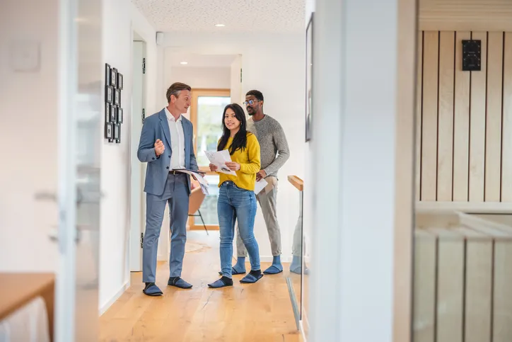 a couple is shown an apartment by a property manager