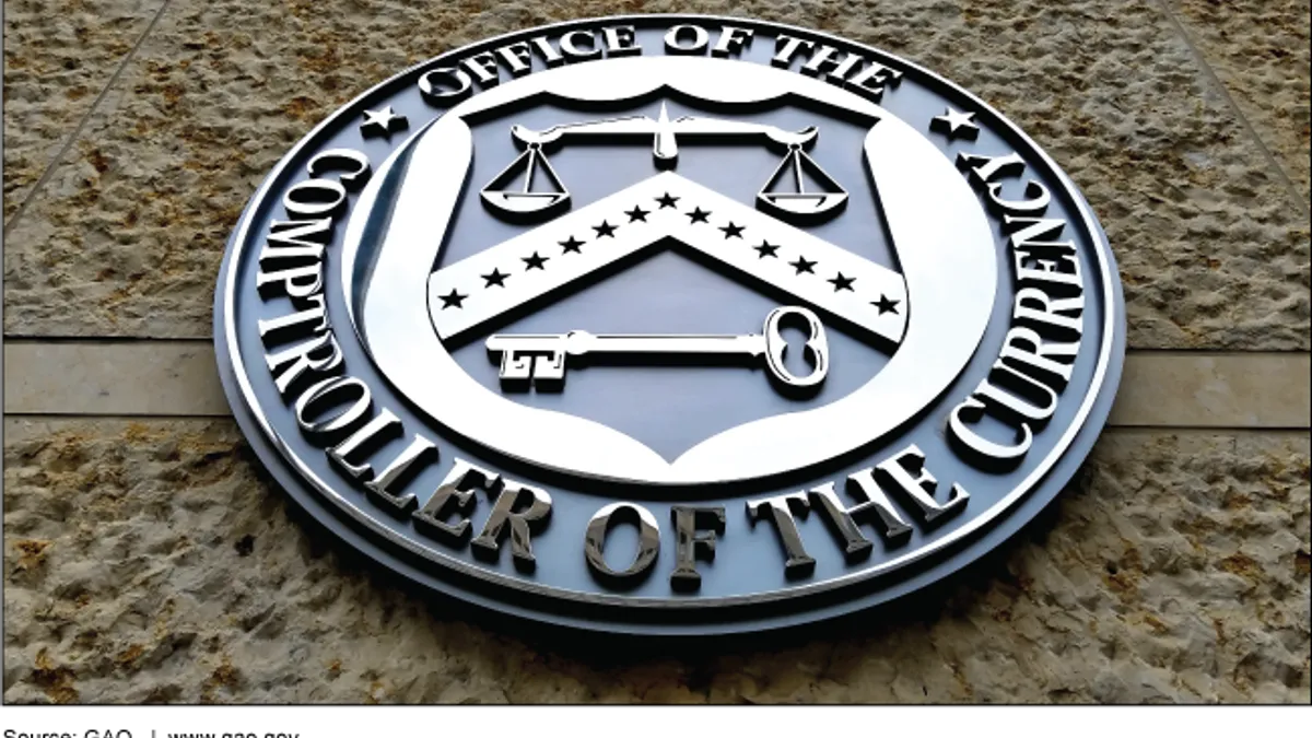 The Office of the Comptroller of the Currency's seal hangs on a brick building.