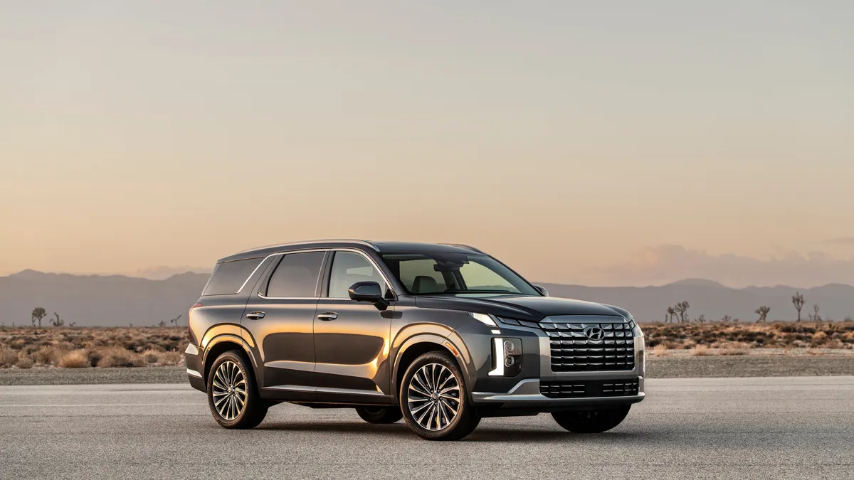 The 2024 Hyundai Palisade SUV parked outside with mountains in the background.