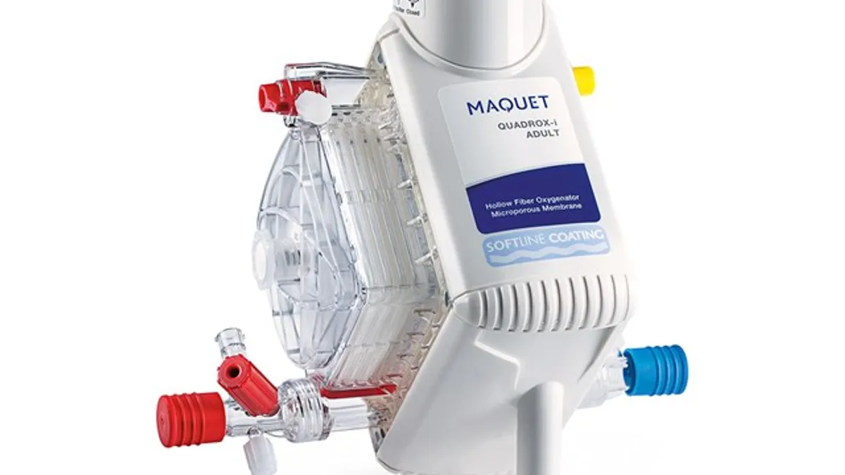 A white device with attachments for tubes says 'Maquet Quadrox-I Adult'