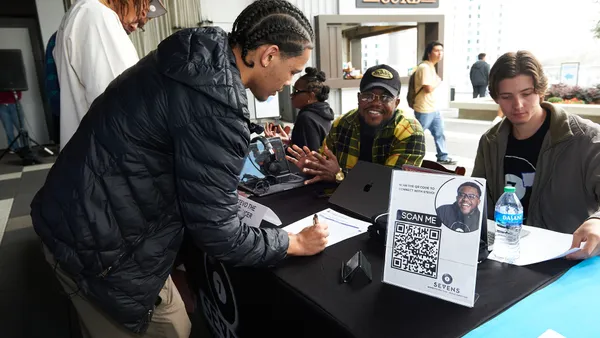 An individual visits a job fair booth.