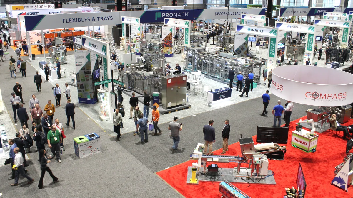 An aerial view of exhibitors set up in a large convention hall.