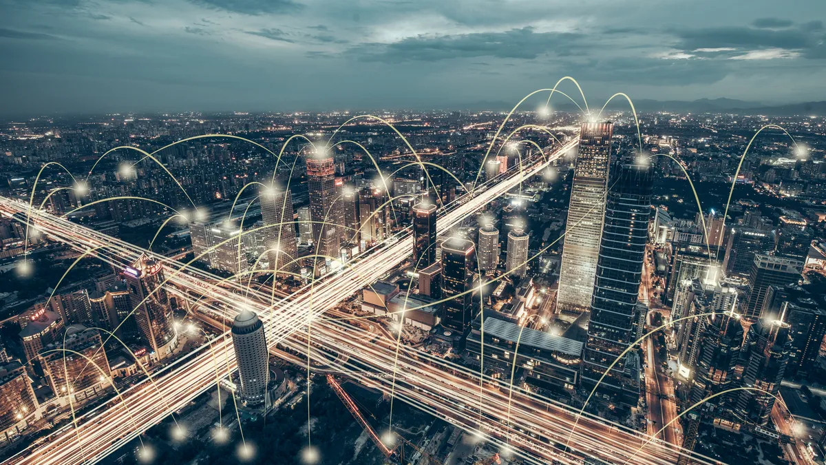 An illustration shows a city at night with white lines connecting structures reaching up the cloud.