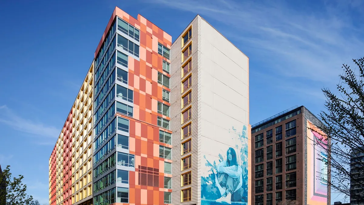 An apartment building with a mural of a woman on the side.