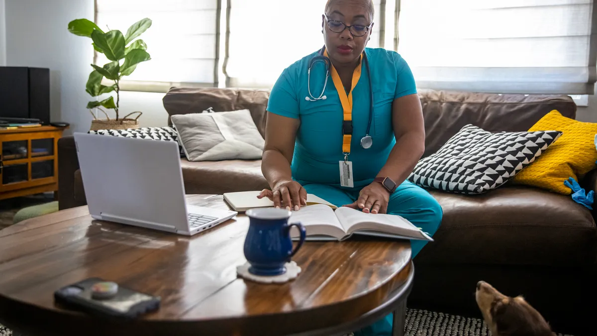 A black female nurse studying for another degree studies between her shifts.