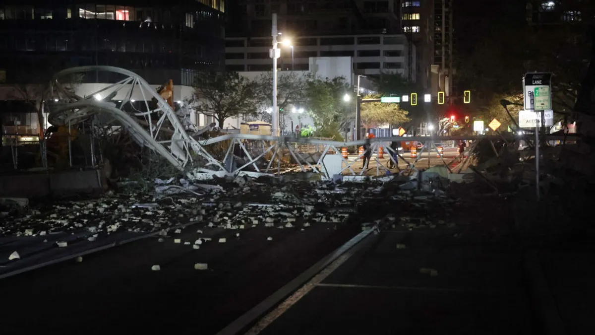 A collapsed tower crane lays across a dark road