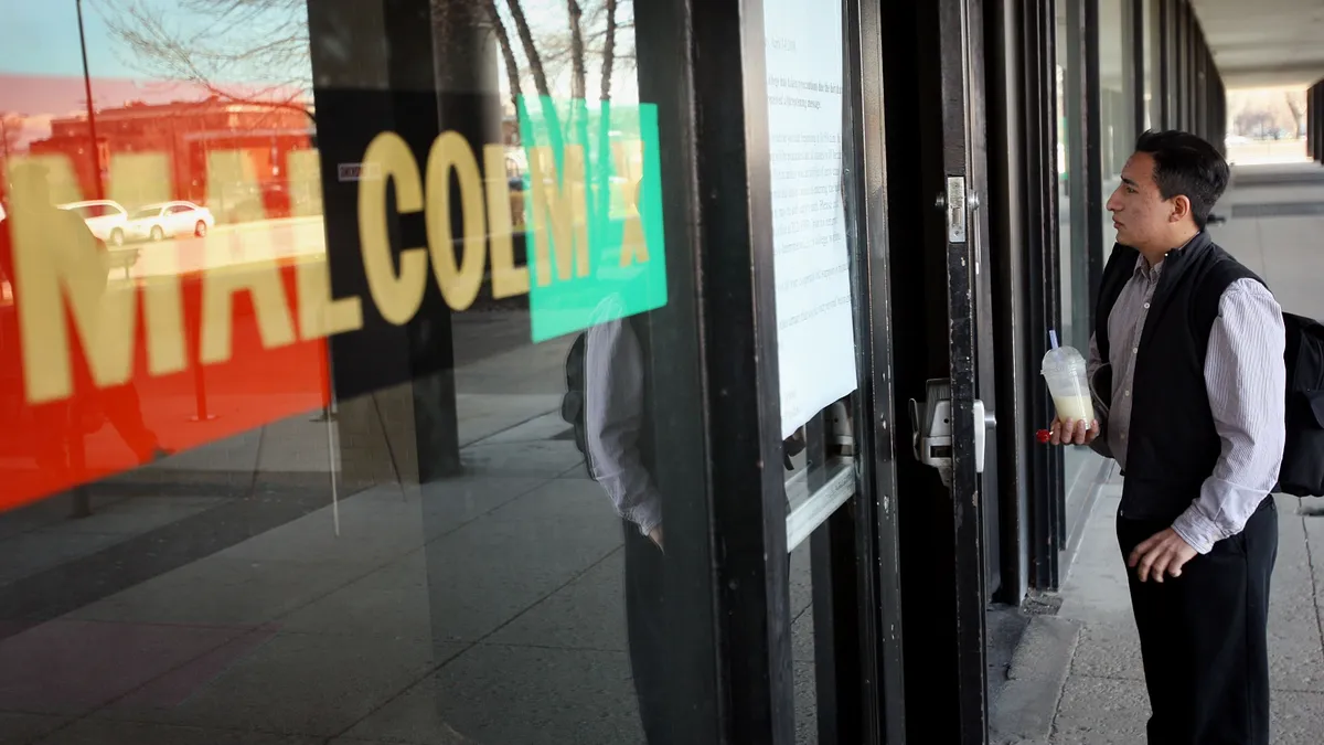 A person looks at a door of the campus of Malcolm X College.