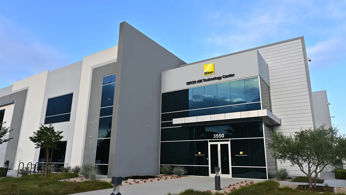 A gray and white building with the yellow Nikon logo sign above the windows