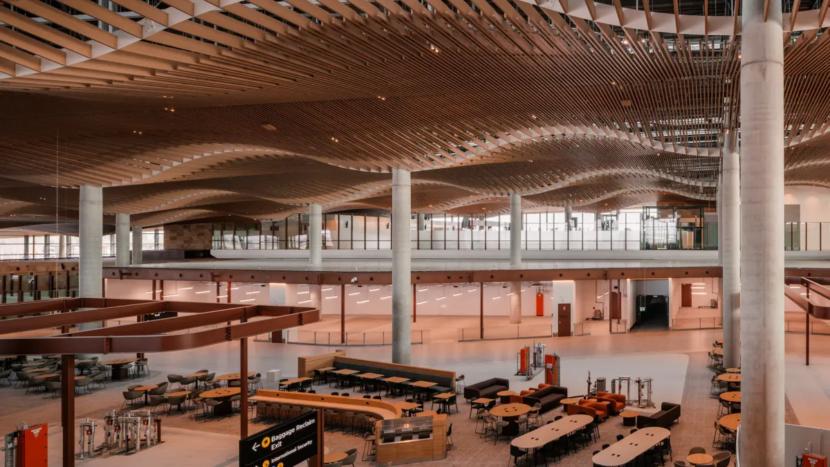 A large, open interior of an open space with a wood-seeming roof.