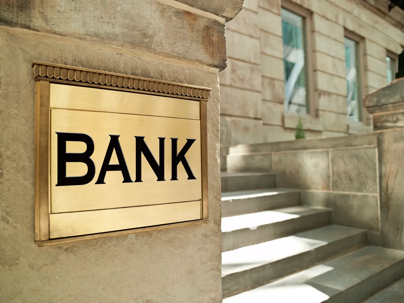 Bank plaque pictured on a city building housing a financial company.